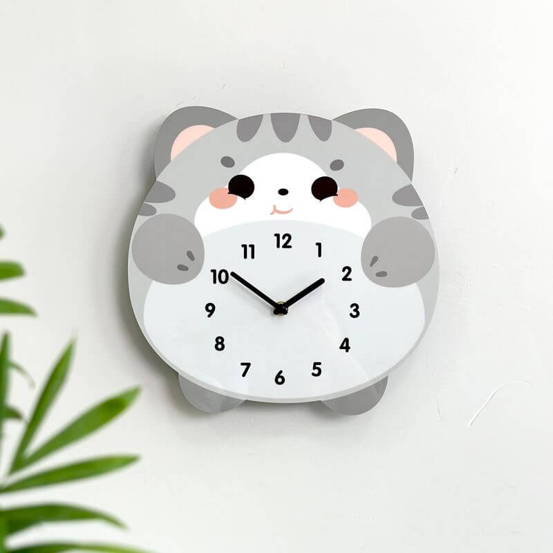 British Shorthair blue cat clock on white wall with green plant and home decor items