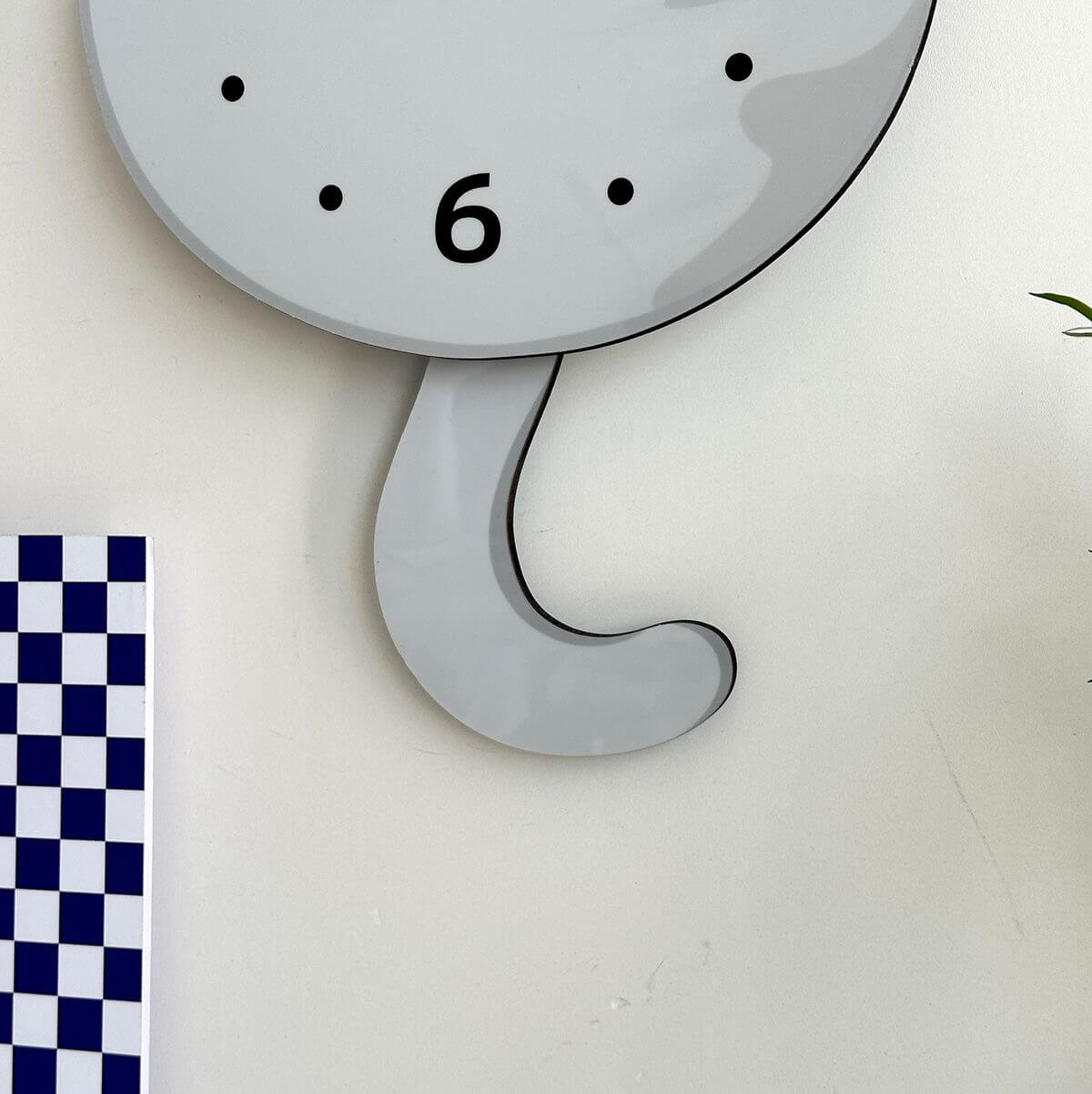 British Shorthair silver shaded wall clock in room setting with plant and decorative items