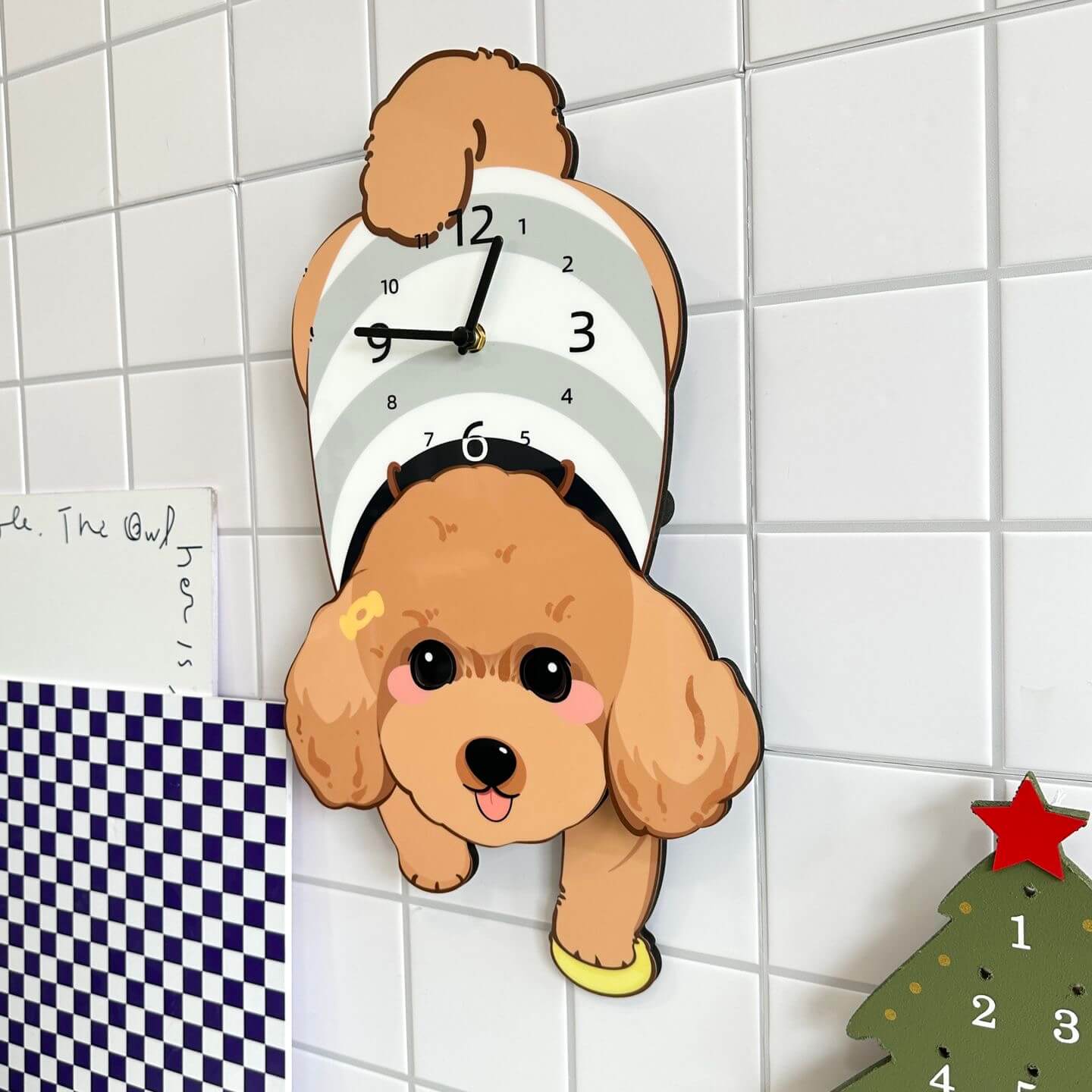 Brown Poodle lying clock on white wall with green plant and home decor items