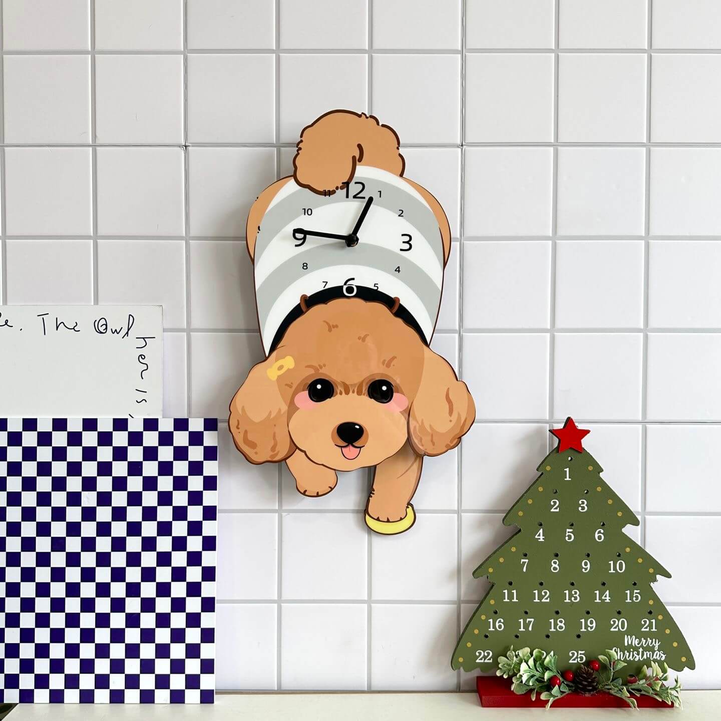 Brown Poodle lying wall clock mounted on clean white wall with green plant decor