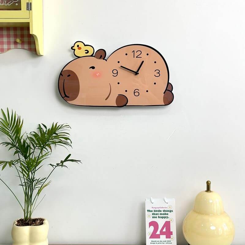 Capybara sleepy wall clock on cream wall with yellow cabinet, plant, calendar and gourd