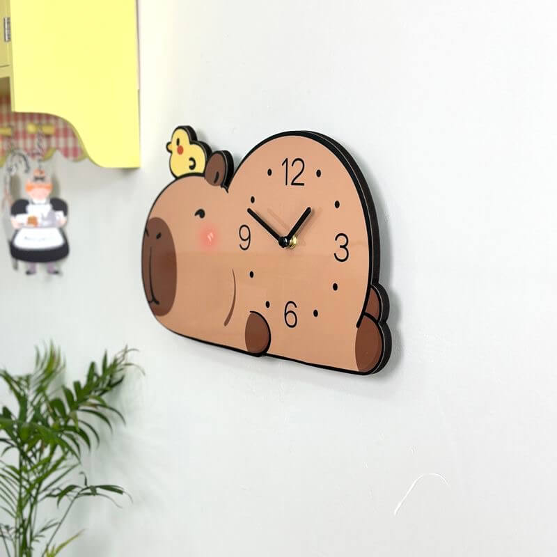 Capybara lying clock side angle on white wall with yellow cabinet and kitchen figurine
