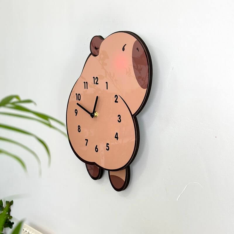 Capybara lying clock front view on white wall with green plant