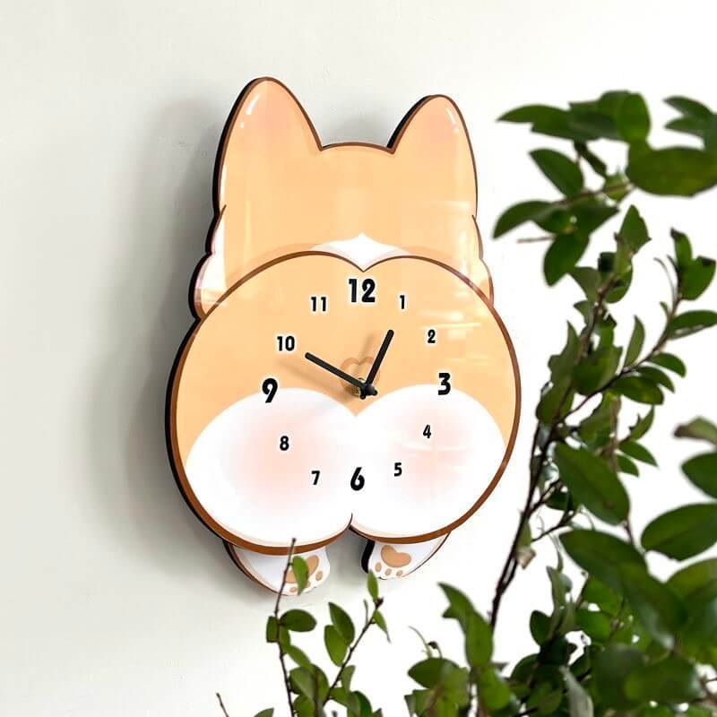 Corgi butt clock front view on white wall with green plant