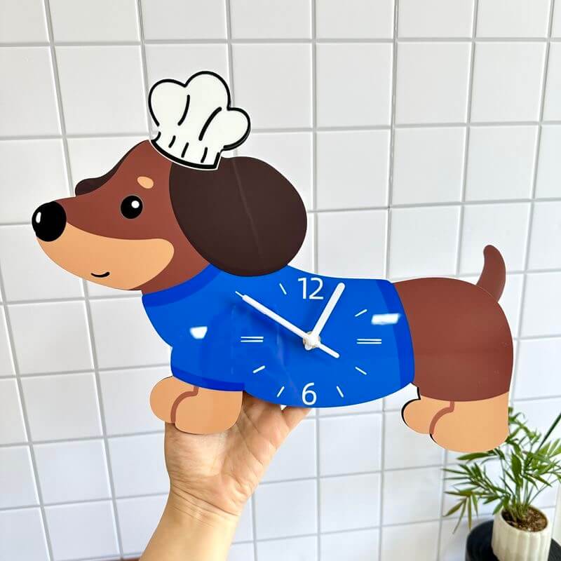 Dachshund chef hat clock held in hand on white tile wall - size demonstration