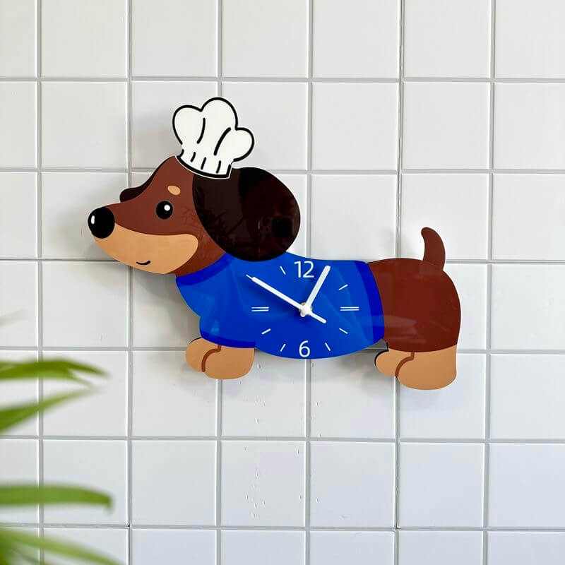 Dachshund chef hat wall clock on white tile wall with blurred green plant in foreground