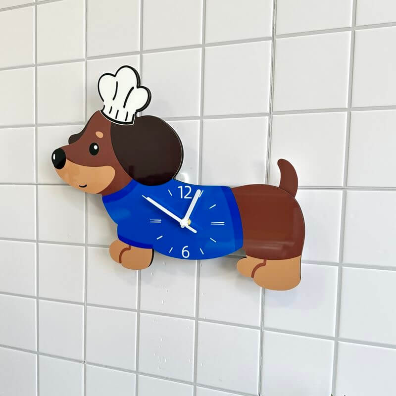 Dachshund dog-shaped wall clock mounted on a white tile wall, slight side angle view