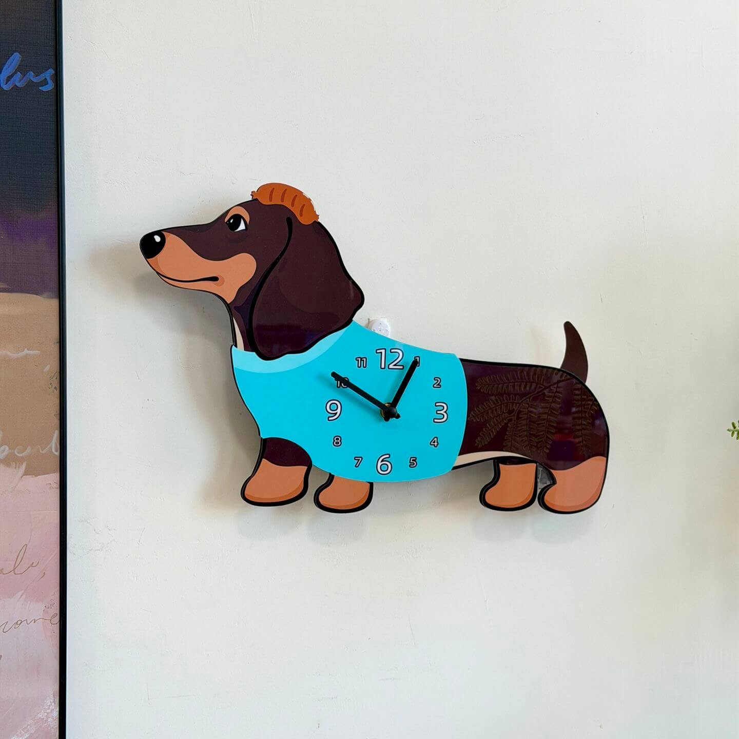 Dachshund dark brown clock on white wall with green plant and home decor items
