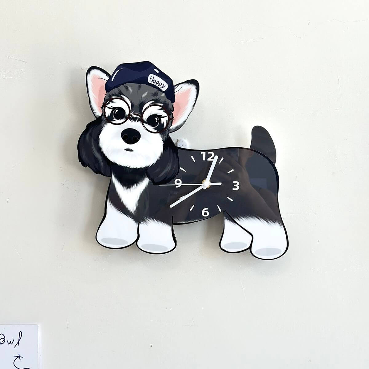 Schnauzer dog-shaped wall clock hanging on a plain cream-colored wall