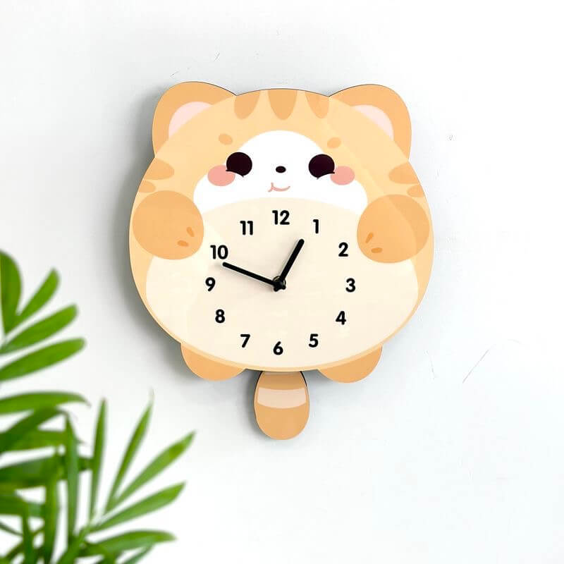 Orange tabby lying cat clock on white wall with green plant and home decor items