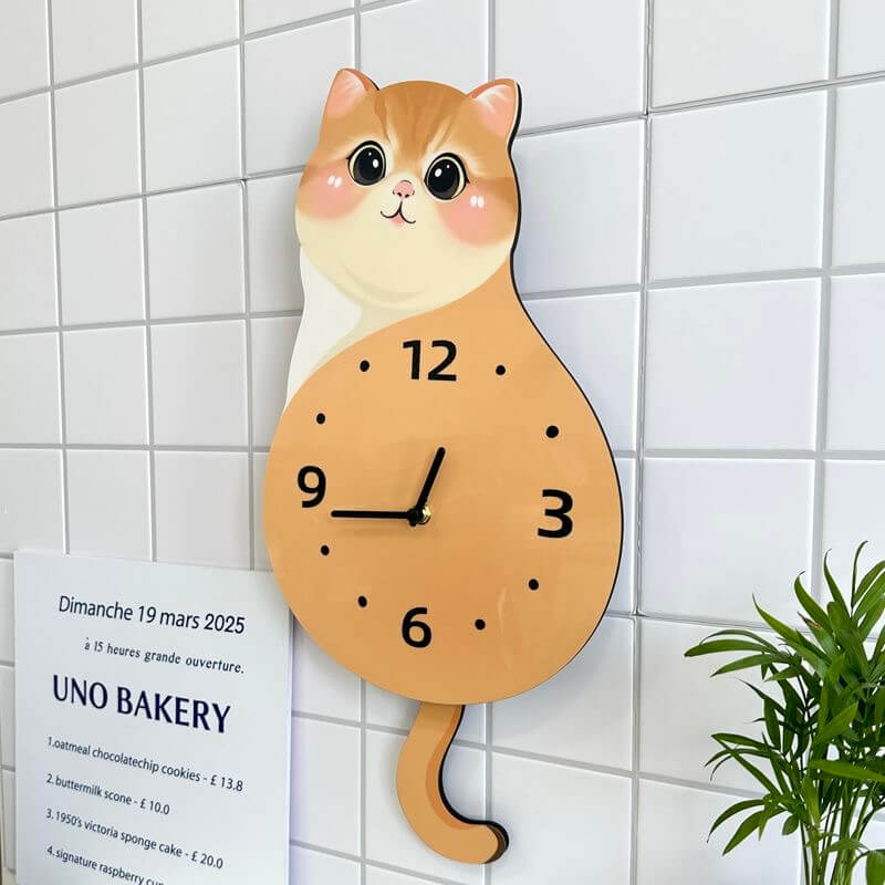 Orange tabby sitting cat wall clock angled view showing cute face and long tail