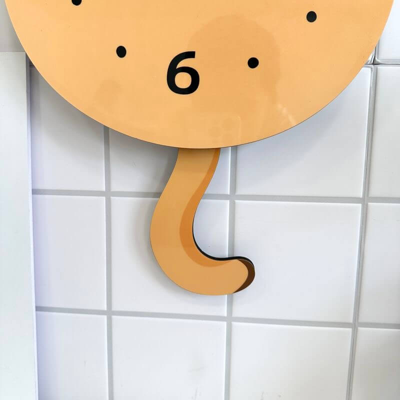 Orange tabby sitting cat clock close-up showing adorable face and pink blush
