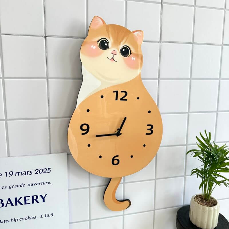 Orange tabby sitting cat clock on white wall with green plant and home decor items